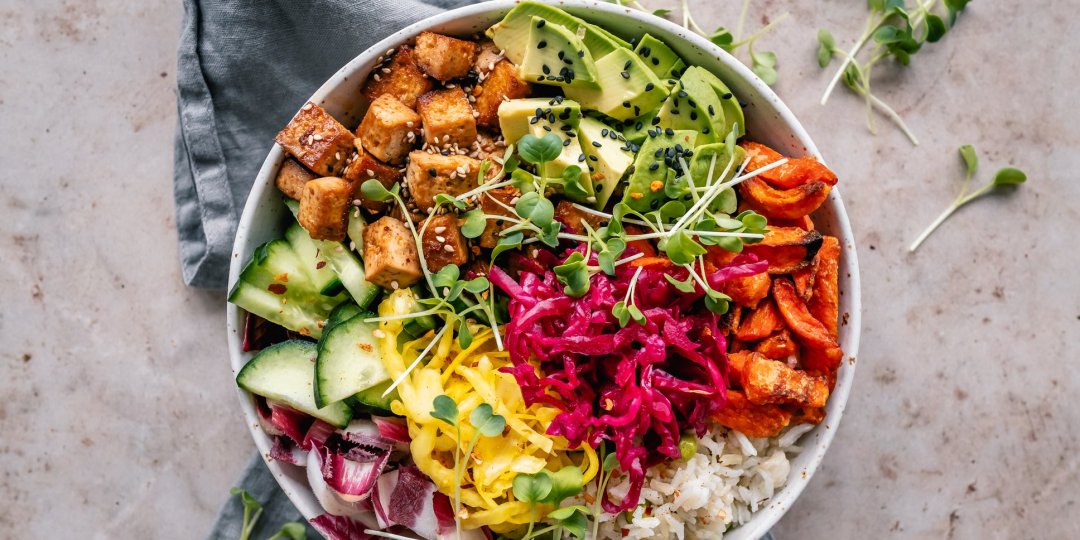 Buddha bowl with pan roasted tofu, avocado, sweet potato, rice, vegetables and mixed seeds
