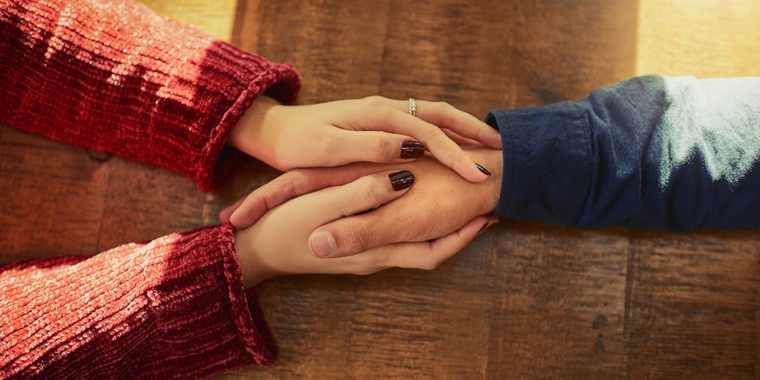 Cropped high angle shot of a man and woman holding hands on a table