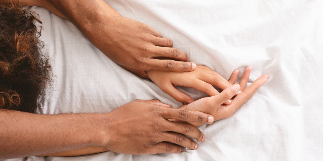 Man and woman hands having sex on bed