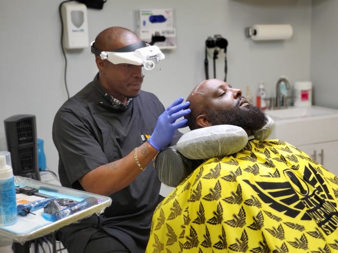 Donell Bryant, owner of Elite Scalp Micro Studio is pictured performing scalp micropigmentation procedure with client Corey Hargett.