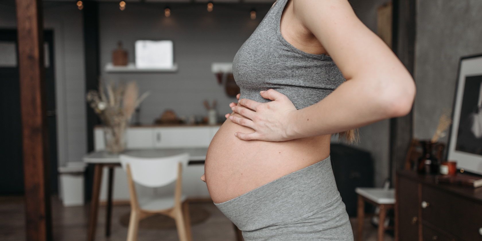 Close up of pregnant woman putting hands on large stomach