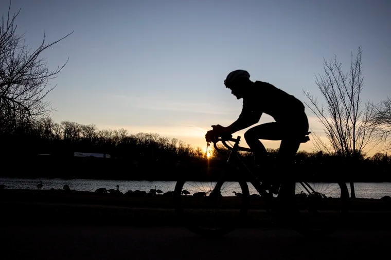 A biker rides along the Schuylkill on the runner and bike paths near Kelly Drive in the afternoon as the sun starts to set on Jan. 17, 2020.
